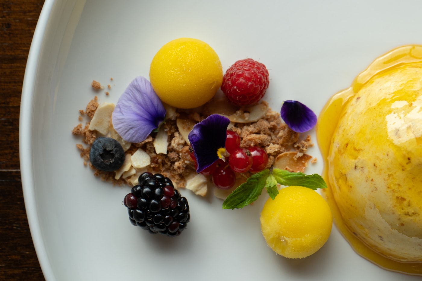 A plated dessert with fruit and cream.