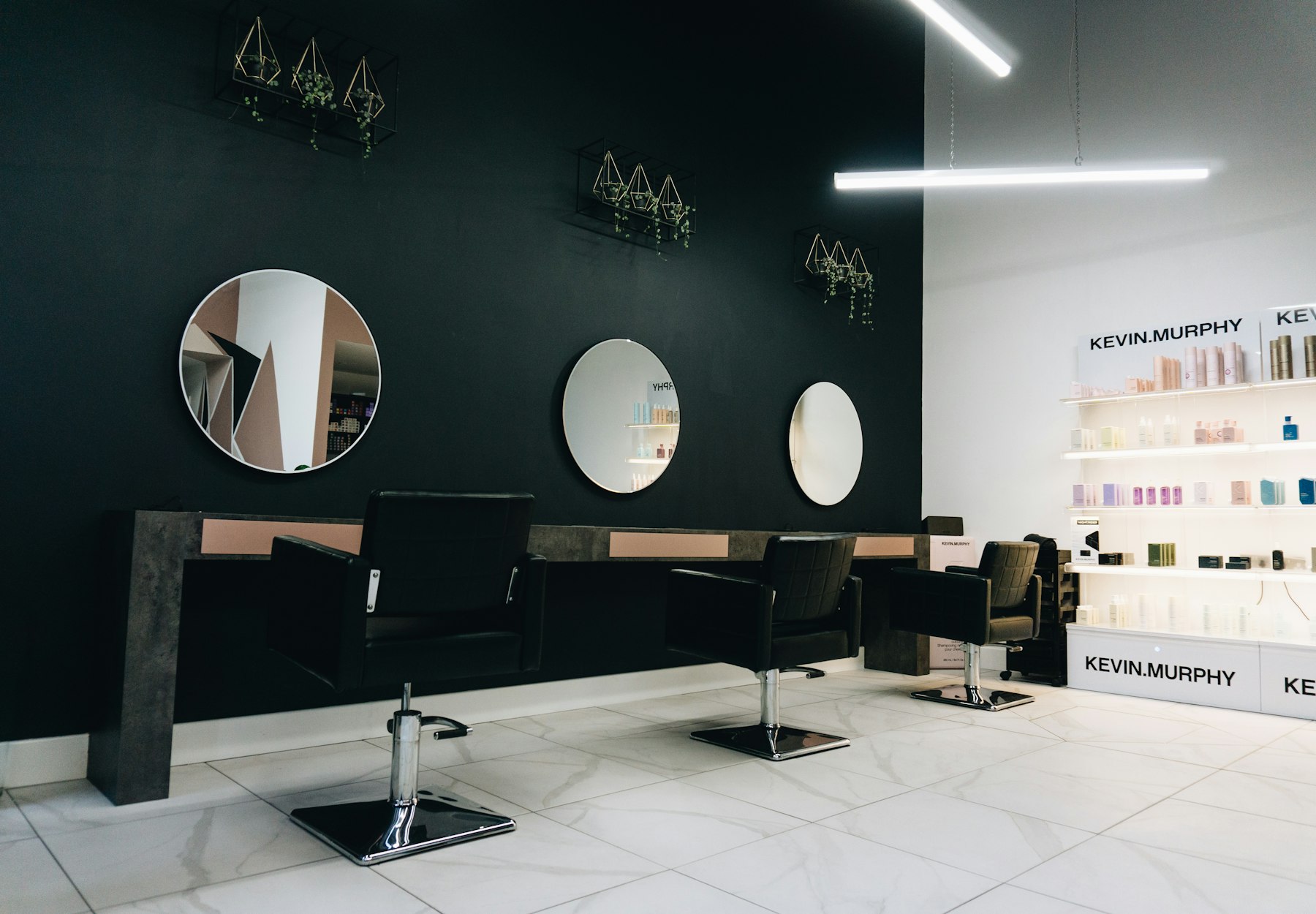 The studio: black chairs facing round mirrors.